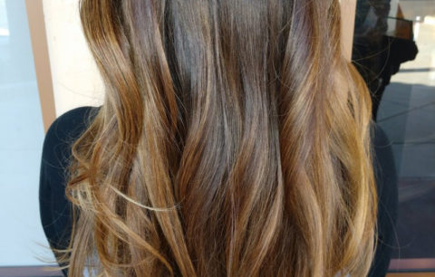 Long wavy hair with caramel and golden ribbons of color, back view